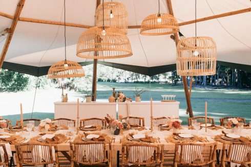 A table setting for a tipi wedding at The Acre featuring beautiful hanging installations and flowers.