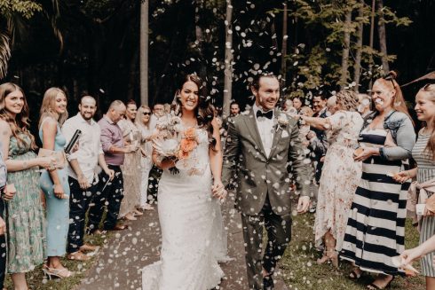 a wedding ceremony on the deck. The bride and groom are being showered in confetti.
