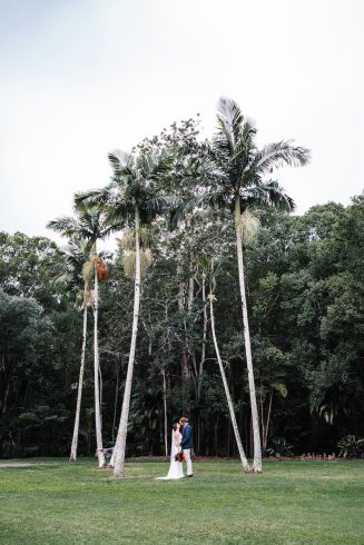 A bride under massive palm trees, a beautiful location fora photo at the acre