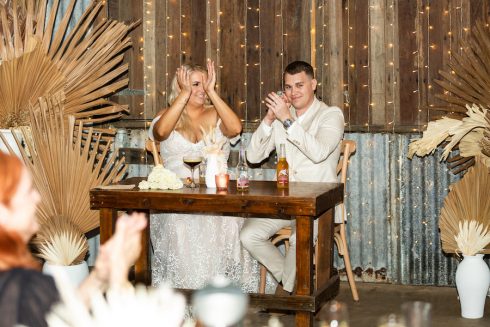 Bride + groom clapping at reception